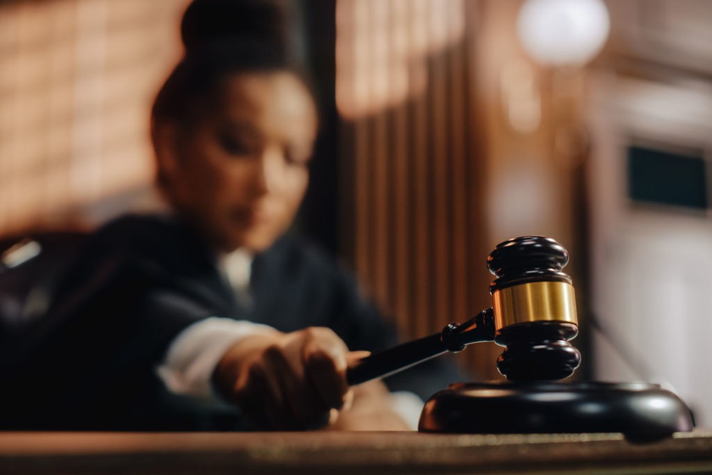 Women Judge hitting gavel at bench in a courtroom